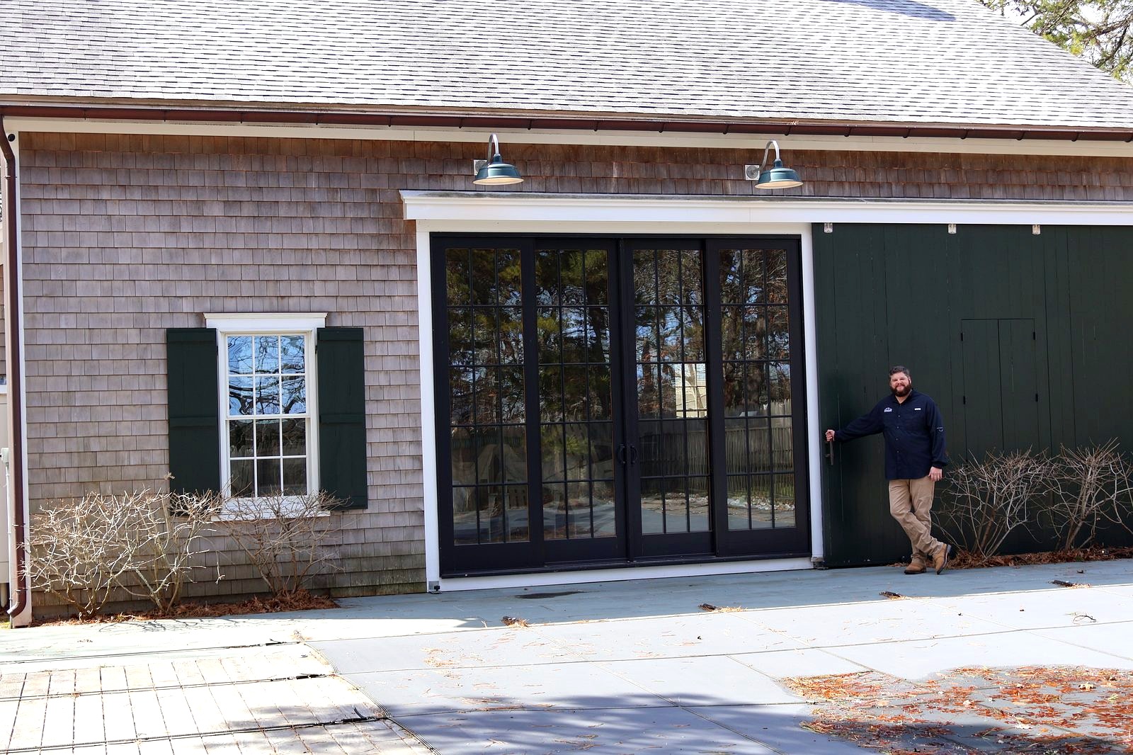 Black patio door system installed on Cape Cod shingle home